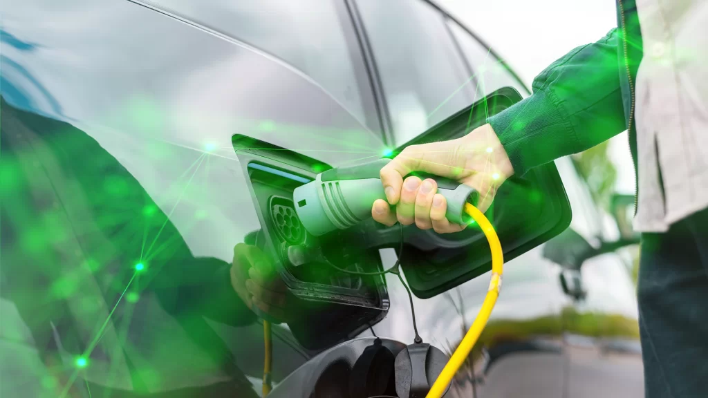 man-plugging-charger-into-electric-car-charge-station-green plexus