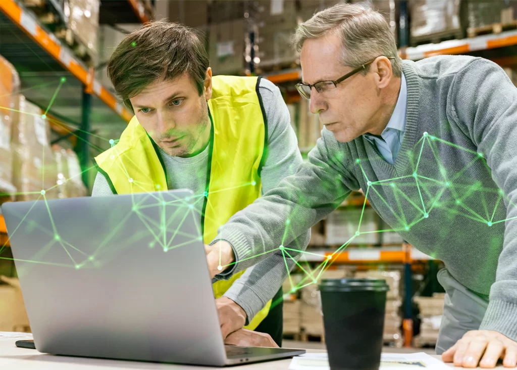 men working at a laptop in a warehouse with a green plexus overlayed