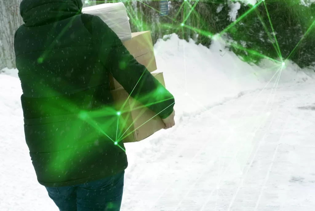 man in black jacket holding boxes with green plexus