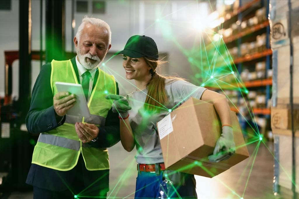 old man in hi-vis and young woman holding box both looking at tablet with green plexus overlayed