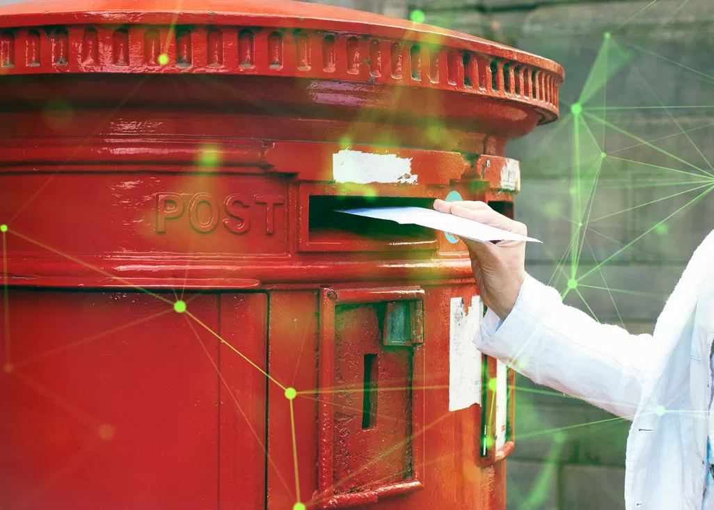 woman putting letter in red postbox with green plexus overlayed