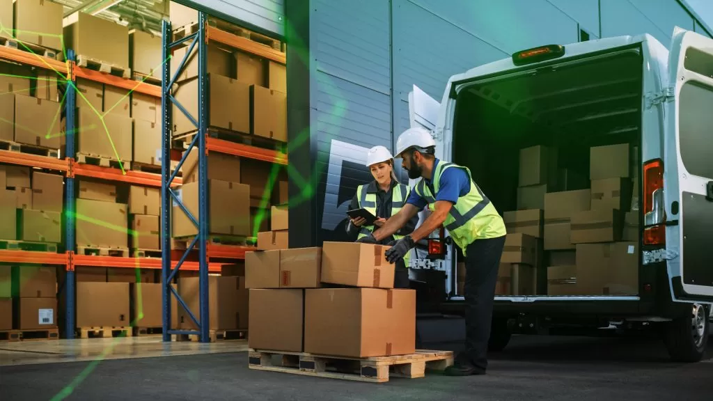 logistics warehoure two workers use hand pallet truck start loading delivery truck with cardboard boxes green plexus