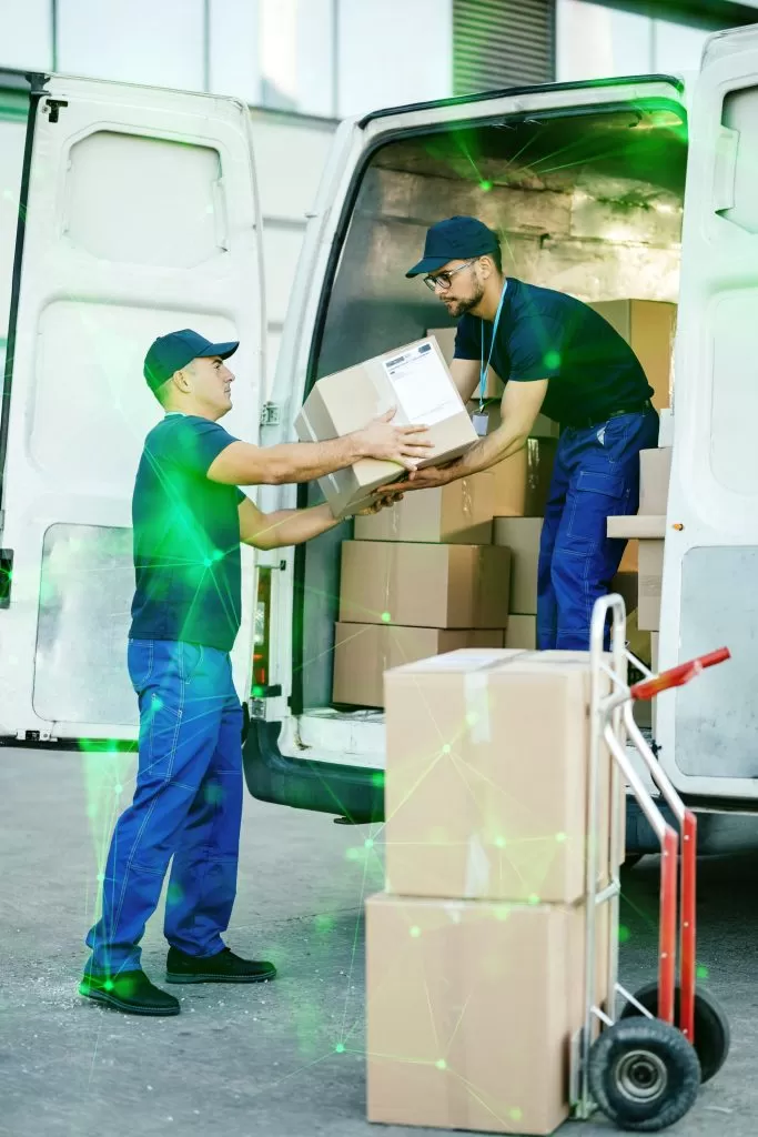 male workers coorperating while loading cardboard boxes delivery van green plexus