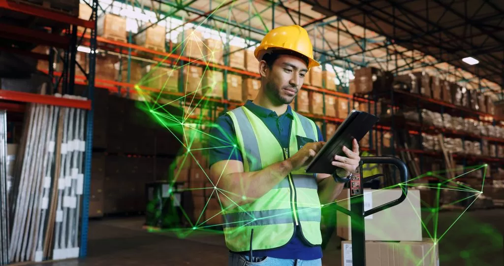 man in warehouse wearing protective equipment on looking at ipad outbound logistics green plexus