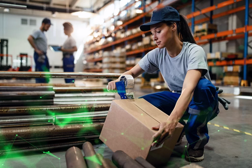 female wareouse worker taping cardboard box with tape dispenser before shipment outbound logistics green plexus