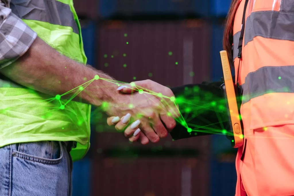 man and woman in hi vis shaking hands with green plexus