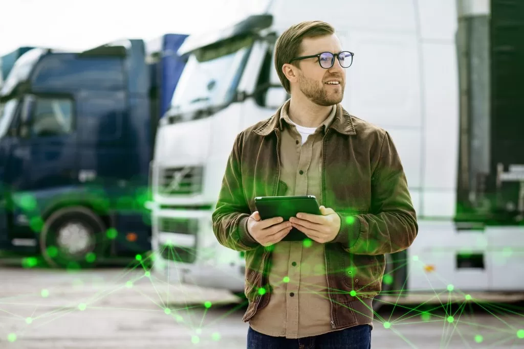 truck-driver-standing-by-his-lorry-using-tablet-green-plexus