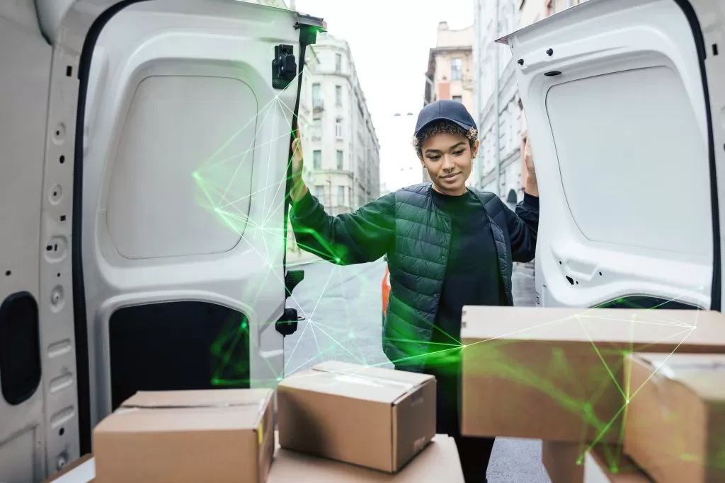 female delivery driver closing doors of van with packages inside green plexus overlay