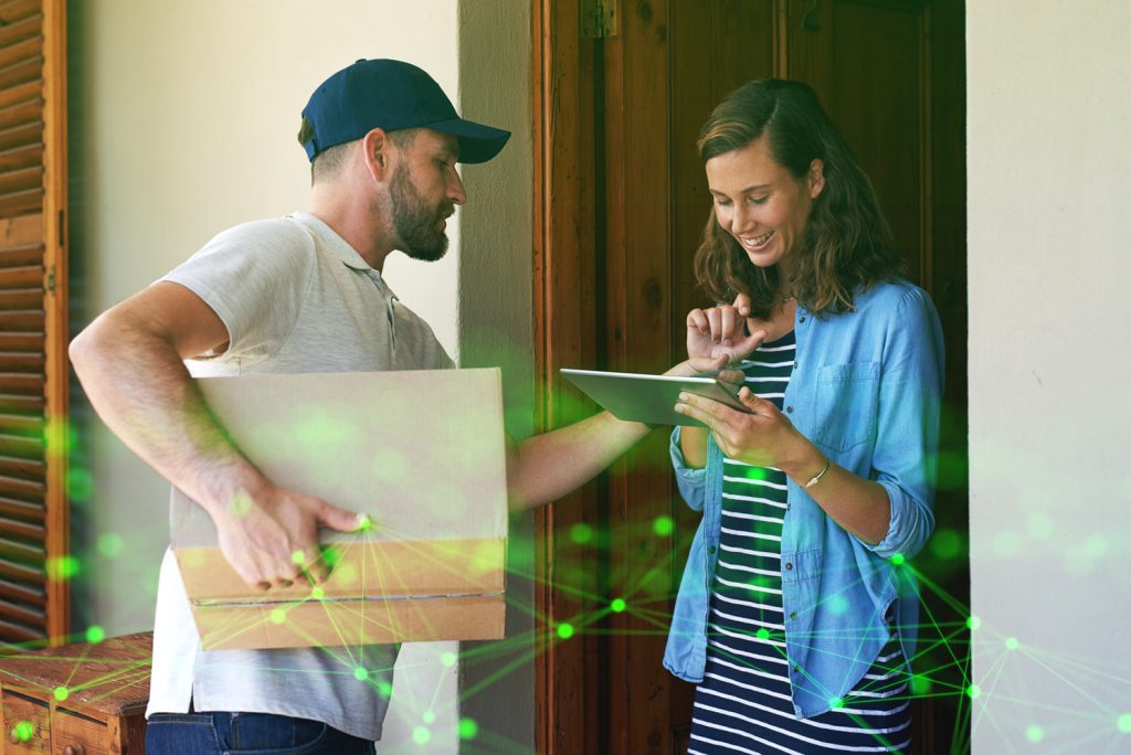 woman signing pod to receive package from male courier with green plexus overlay